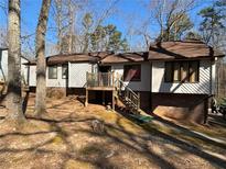 Charming split-level home featuring wood siding, brick foundation, and a cozy front porch with steps at 708 Raven Springs Trl, Stone Mountain, GA 30087