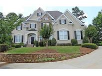 Elegant two-story home featuring a well-manicured front yard and a stone retaining wall at 120 Pine Mist Cir, Alpharetta, GA 30022