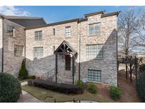 Charming brick townhome with a covered front porch and mature landscaping at 2880 Stonehall Ct # 2, Atlanta, GA 30339