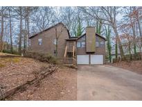 Inviting two-story home with a two-car garage and covered entry, set on a wooded lot at 123 Williamsburg Ln, Woodstock, GA 30189