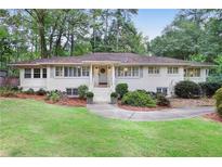 Charming one-story home featuring a landscaped front yard with a walkway leading to the front door at 850 Moores Mill Nw Rd, Atlanta, GA 30327