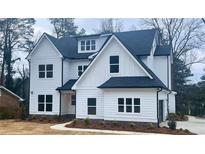 Charming two-story white home featuring black trim, black roof, and manicured landscaping at 2519 Cherry Hill Ln, Atlanta, GA 30360