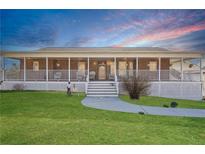 Charming brick home with a welcoming front porch and well-manicured lawn under a blue sky at 3200 Fence Rd, Dacula, GA 30019