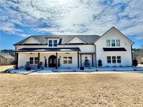 Stunning two-story home featuring a modern farmhouse design and a welcoming front porch with rocking chairs at 590 Hood Ave, Fayetteville, GA 30214