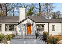 Charming single-Gathering home with a brick exterior, a well-manicured lawn, and a bright orange front door at 10 Claire Se Dr, Atlanta, GA 30315