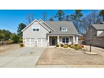 Charming home featuring a two-car garage, a welcoming front porch, and manicured landscaping, perfect for suburban living at 1353 Dogleg Road, Marietta, GA 30066