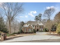 Charming two-story brick home featuring a well-manicured front yard and a spacious circular driveway at 5284 Vernon Springs Trl, Sandy Springs, GA 30327