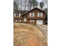 Charming two-story home with a brick and wood exterior, complemented by white trim and an attached garage at 10143 Settlers Grove Ne Rd, Covington, GA 30014