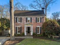 Charming two-story brick home featuring a classic design, black shutters, and a well-manicured front lawn at 586 Collier Rd, Atlanta, GA 30318
