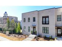 Modern townhome with a light brick facade, dark window trim, and manicured landscaping at 3601 Ridgeway Rd, Duluth, GA 30096