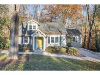 Charming home with a well-maintained lawn, beautiful landscaping, and a bright yellow front door at 3451 Keswick Ct, Atlanta, GA 30341