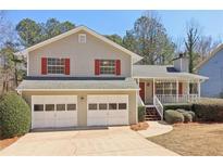 Charming two-story home with a welcoming front porch and a two-car garage at 5537 Riverside Dr, Sugar Hill, GA 30518