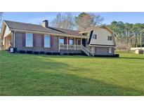 Charming brick and vinyl home featuring a well-manicured lawn and inviting front porch at 3415 Spot Rd, Cumming, GA 30040