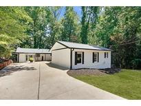 Charming single-story home with a well-manicured lawn and a long, private driveway at 7360 Fields Dr, Cumming, GA 30041