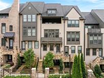 Stunning townhome features a well-manicured lawn, and private entrances, a sophisticated look with grey and white brick facade at 6657 Encore Blvd, Atlanta, GA 30328