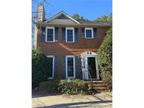 Charming two-story brick home with blue shutters and a well-manicured front yard at 866 Indian Lake Nw Dr, Lilburn, GA 30047