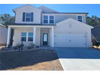 Charming two-story home featuring a welcoming front porch and a two-car garage at 4161 Dean Grove Way, Loganville, GA 30052