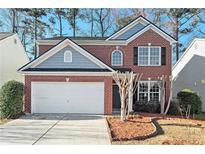 Charming brick home featuring a two-car garage and manicured landscaping at 885 Clairidge Ln, Lawrenceville, GA 30046