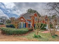Charming brick home with well-manicured front yard and mature landscaping, offering great curb appeal at 9235 Heatherton Walk, Duluth, GA 30097