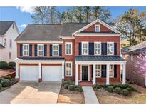 Charming brick two-story home with black shutters, covered porch, and well-manicured landscaping at 1545 Heritage Trl, Roswell, GA 30075
