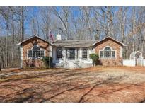 Charming stone-accented home with a welcoming front yard and a quaint white picket fence and arbor at 332 Stonecutters Cv, Stockbridge, GA 30281