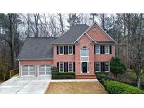 Charming two-story brick home with a well-manicured lawn, black shutters, and a two car garage at 492 Broadstone Nw Way, Acworth, GA 30101