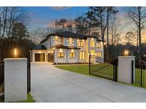 Elegant two-story home with modern design, black framed windows, gated entry and professional landscaping at 5238 Timber Ridge Rd, Marietta, GA 30068