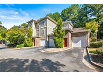 Attractive townhome showcasing mature landscaping, brick accents, and convenient garage entrances at 2700 Pine Tree Ne Rd # 3010, Atlanta, GA 30324