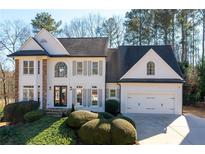 Charming home featuring stone accents, a two-car garage, and a professionally landscaped yard at 2038 Cresthaven Walk, Woodstock, GA 30189