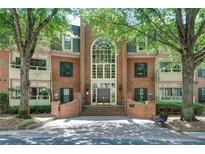 Elegant brick condo building featuring a grand entrance and mature trees at 25309 Plantation Ne Dr # 309, Atlanta, GA 30324