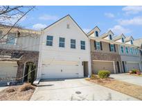 Beautiful townhouse with a two-car garage and white brick facade under a clear blue sky at 2978 Edgemont Ln, Marietta, GA 30008