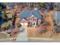 Charming two-story brick home featuring a well-manicured front lawn and attached two-car garage at 2678 Stockbridge Way, Dacula, GA 30019