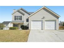 Charming two-story home features a two-car garage, well-maintained lawn, and classic curb appeal at 7282 Williamsburg Dr, Riverdale, GA 30274