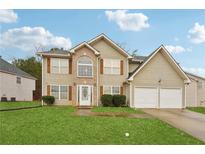 Charming two-story home with a well-maintained lawn and two-car garage, offering a blend of comfort and curb appeal at 3308 Hunting Creek Pass, Douglasville, GA 30135