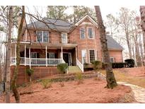 Charming two-story brick home with covered porch, dormer windows, and mature landscaping at 3527 Kellogg Creek Rd, Acworth, GA 30102