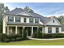 Beautiful two-story home with a large front porch and well-manicured landscaping creating great curb appeal at 140 Discovery Lake Dr, Fayetteville, GA 30215