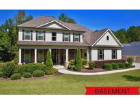 Charming two-story home featuring a manicured lawn, covered porch, and classic architectural details at 140 Discovery Lake Dr, Fayetteville, GA 30215