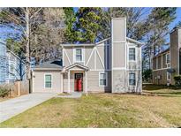 Charming home with a red front door, neutral siding, and a well-maintained front lawn at 6218 Creekford Ln, Lithonia, GA 30058