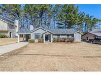 Charming single-story home with gray siding, a covered carport, and a well-maintained front lawn at 2419 Leslie Brook Dr, Decatur, GA 30035