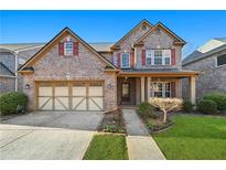 Charming brick home with a well-manicured lawn and a two-car garage at 120 Daniel Creek Ln, Sugar Hill, GA 30518