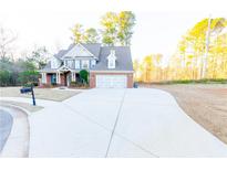 Charming two-story brick home with a spacious driveway and attached two-car garage at 2474 Starfire Ln, Loganville, GA 30052