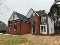 Two story brick and siding home with a gray roof and black shutters at 6910 Stone Breeze Dr, Stone Mountain, GA 30087