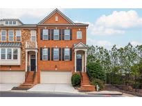 Beautiful brick townhome with black shutters, a front-entry garage, and manicured landscaping at 2826 Loftview Sq # 4, Atlanta, GA 30339