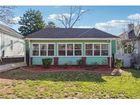 Charming single-story home featuring light green siding, white trim, and a well-manicured front yard at 1474 Athens Avenue Sw Ave, Atlanta, GA 30310