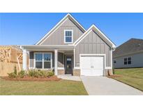 Charming craftsman-style home featuring gray siding, white trim, and a two-car garage on a well-manicured lawn at 71 Colonial Terrace, Villa Rica, GA 30180