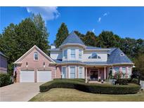 Charming brick home with well-manicured lawn, two-car garage, and turret accents at 190 Winford Close, Duluth, GA 30097