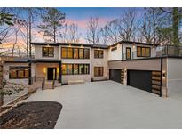 Stunning exterior of a modern home featuring a three-car garage and a sleek, contemporary design at 240 Grogans Lake Pt, Sandy Springs, GA 30350