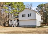 Charming white two-story house with black shutters surrounded by mature trees and a spacious yard at 16 Vaughan Ne Dr, Cartersville, GA 30121