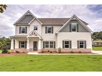 Charming two-story home with landscaped yard, covered porch and neutral-colored siding at 1452 Stephens View Dr, Loganville, GA 30052