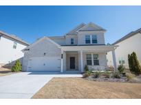 Charming two-story home with a brick facade, a well-manicured lawn, and an attached two-car garage at 880 Elderberry Ct, Lawrenceville, GA 30045